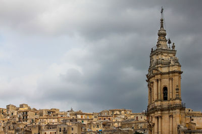 Low angle view of buildings against cloudy sky