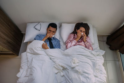 Full length of young man relaxing on bed at home