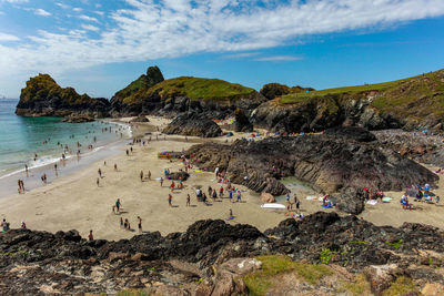 Group of people on beach against sky