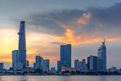 View of skyscrapers against cloudy sky during sunset