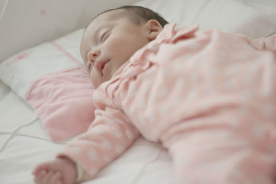 Close-up of baby sleeping on bed