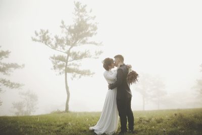 Full length of couple standing on field