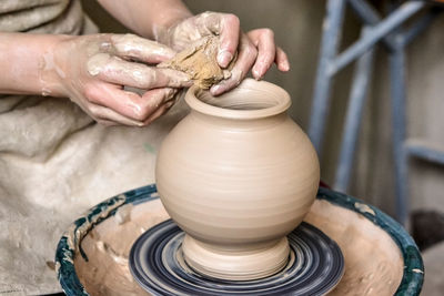 Making crock crude wet. man hands and tool making clay jug. sculptor in workshop makes jug of clay 