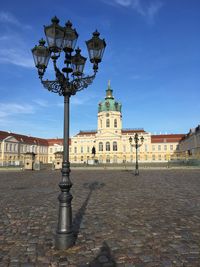 Street light by building against sky