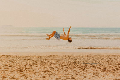 Full length of man jumping on beach