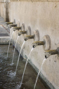 Detail of the snake shape pipes on the wall fountain in xativa, valencia, spain