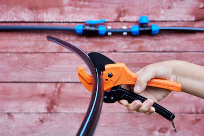 Cropped hand holding equipment on table