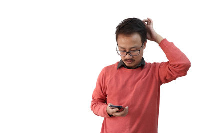 Portrait of young man standing against white background