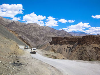 Cars on road amidst desert against sky