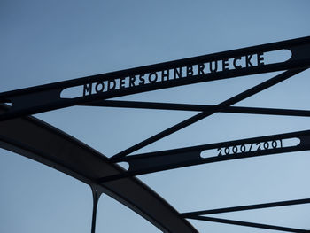 Low angle view of text on bridge against sky