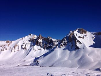 Scenic view of snowcapped mountains against clear blue sky