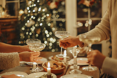 Midsection of woman holding illuminated christmas tree