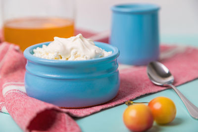 Cottage cheese in a blue bowl with sour cream and honey.