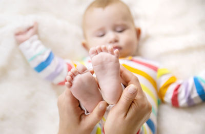 Mother holding baby feet at home