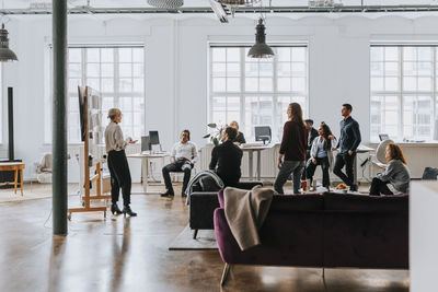 Businesswoman discussing business strategy with multiracial colleagues in office