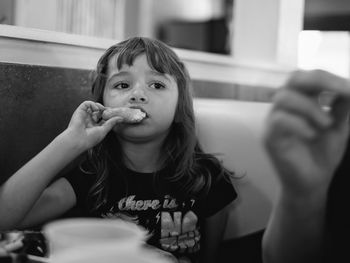 Portrait of girl eating food at home