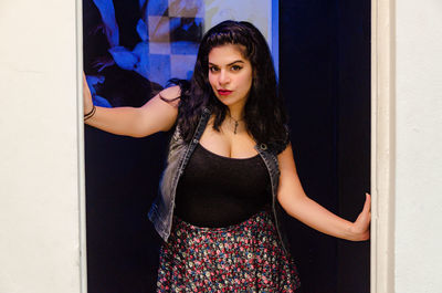 Young woman standing against wall