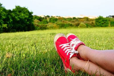 Low section of woman relaxing on grassy field