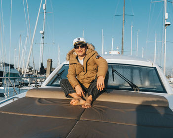 Low angle view of man sitting on the yacht