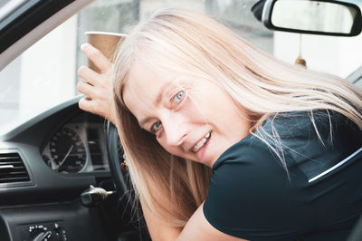 Portrait of young woman in car