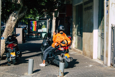 Man and motor scooter on street in city