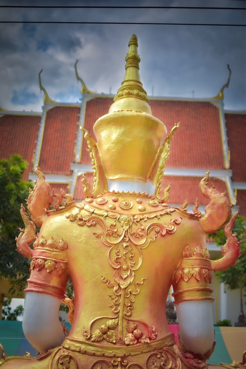 BUDDHA STATUE AGAINST BUILDING