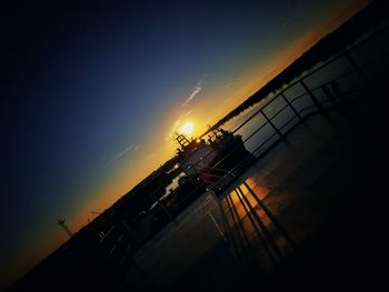 Silhouette people by sea against sky during sunset