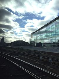 Railroad tracks against cloudy sky