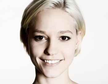 Portrait of smiling young woman against white background