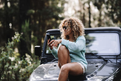 Young woman using mobile phone while sitting in car