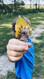 Close-up of hand holding yellow flower