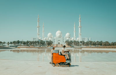 Man sitting in temple against clear sky