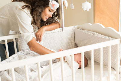 Mother looking at son in crib