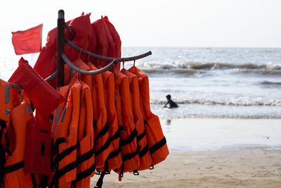 Red umbrella on beach against clear sky