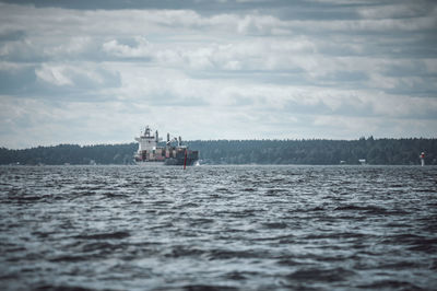 Ship sailing on sea against sky