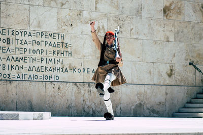 Full length portrait of man standing against wall