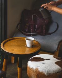 Hand holding coffee cup on table