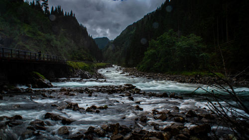 Scenic view of river amidst mountains against sky