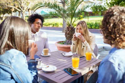 Friends using mobile phone while sitting at restaurant