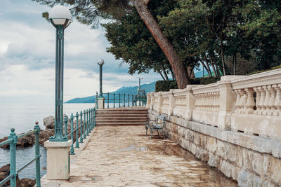 Footpath by sea against sky