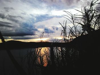 Scenic view of sea against cloudy sky at sunset