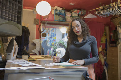 Portrait of young female artist at work in her studio