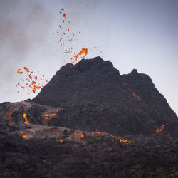 Scenic view of fire on mountain against sky