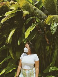 Portrait of woman standing amidst plants