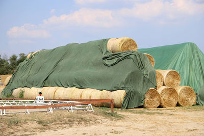 Hay bales on field against sky