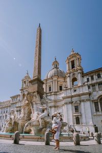 Couple embracing against historical building