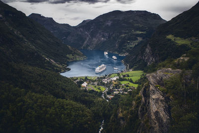 High angle view of stream amidst trees and mountains against sky