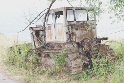 Low angle view of abandoned vehicle on field