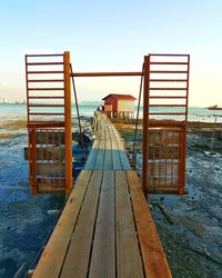 Pier on beach against sky