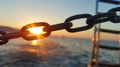 Close-up of chain against sky during sunset